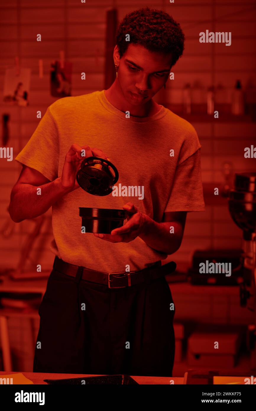 handsome photographer holding film canister and developing photos in