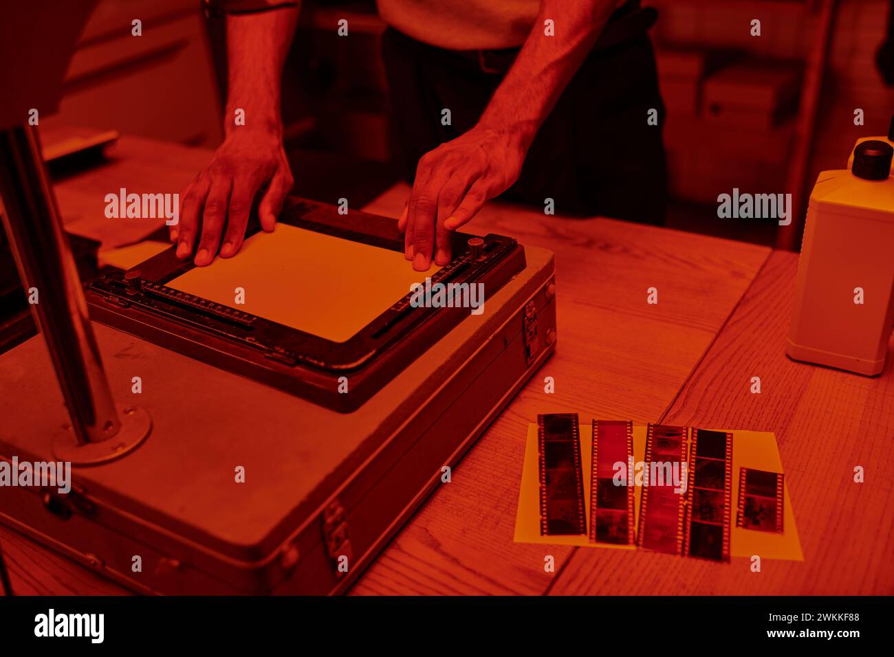 cropped young man focuses on delicate process of enlarging film in