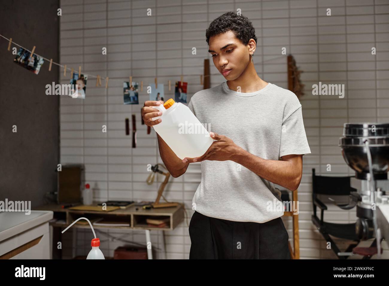 young african american photographer holding chemical solution in