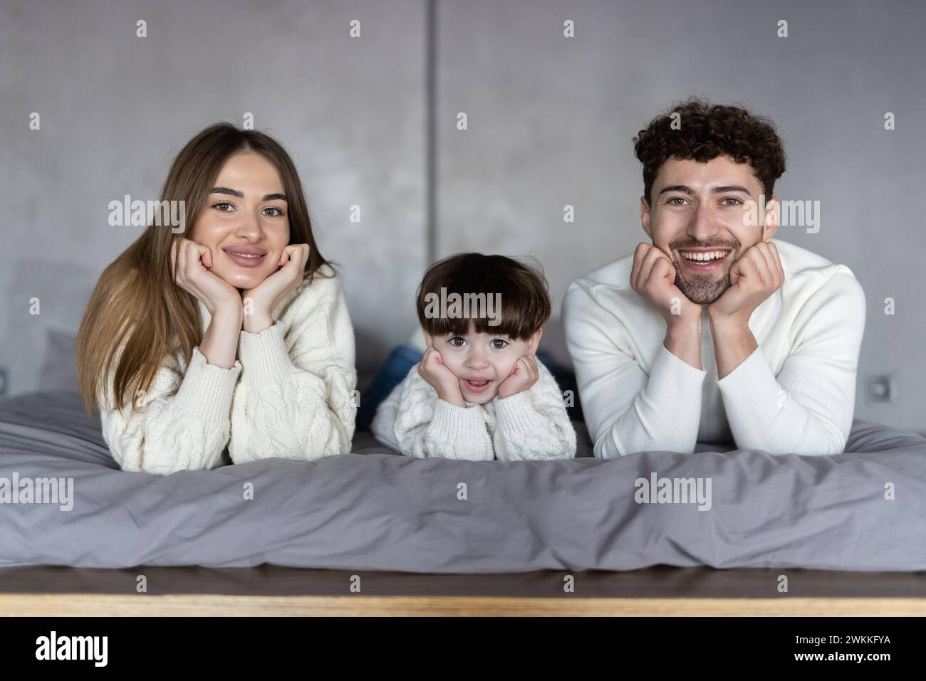 Young attractive family on a bed Stock Photo
