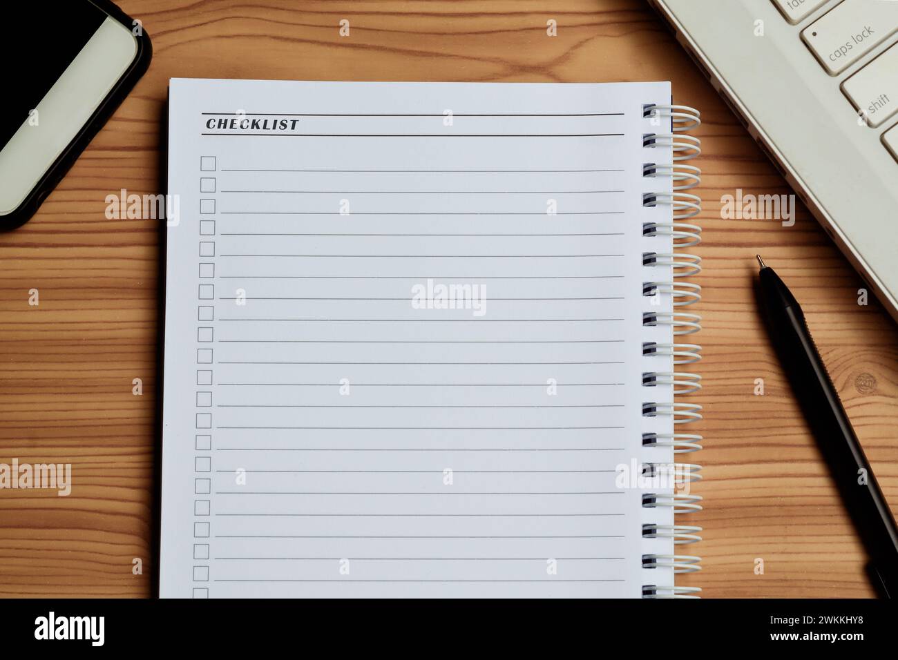 Blank checklist with space for ticks on notepad with laptop, smartphone ...