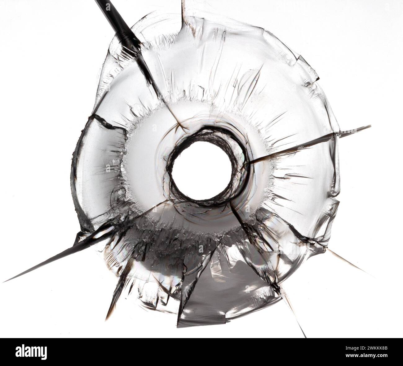 Isolated bullet hole on glass. Cracked glass texture on white background. Stock Photo