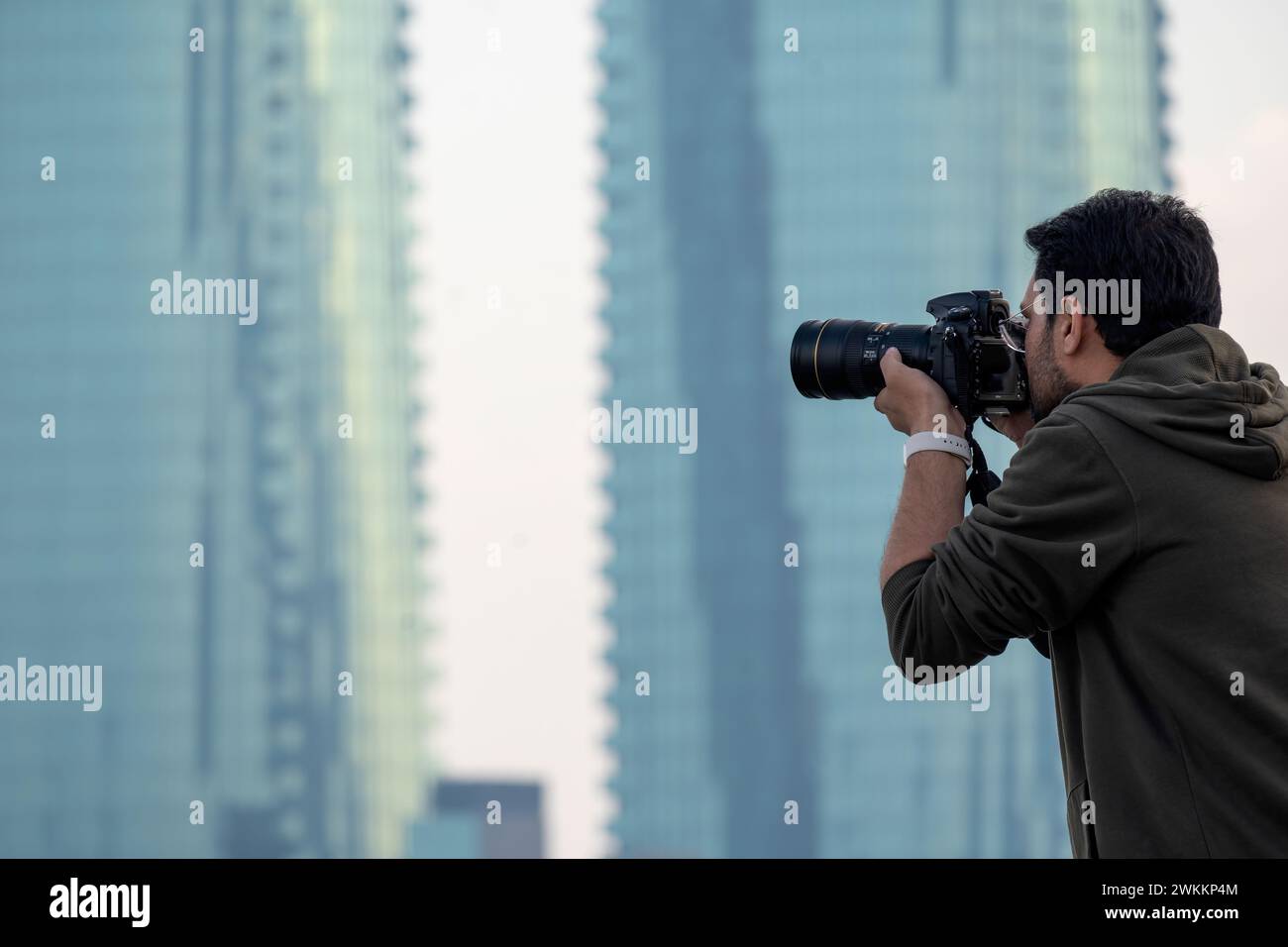 Male Photographer taking photos of skyline Manama City Bahrain Stock Photo