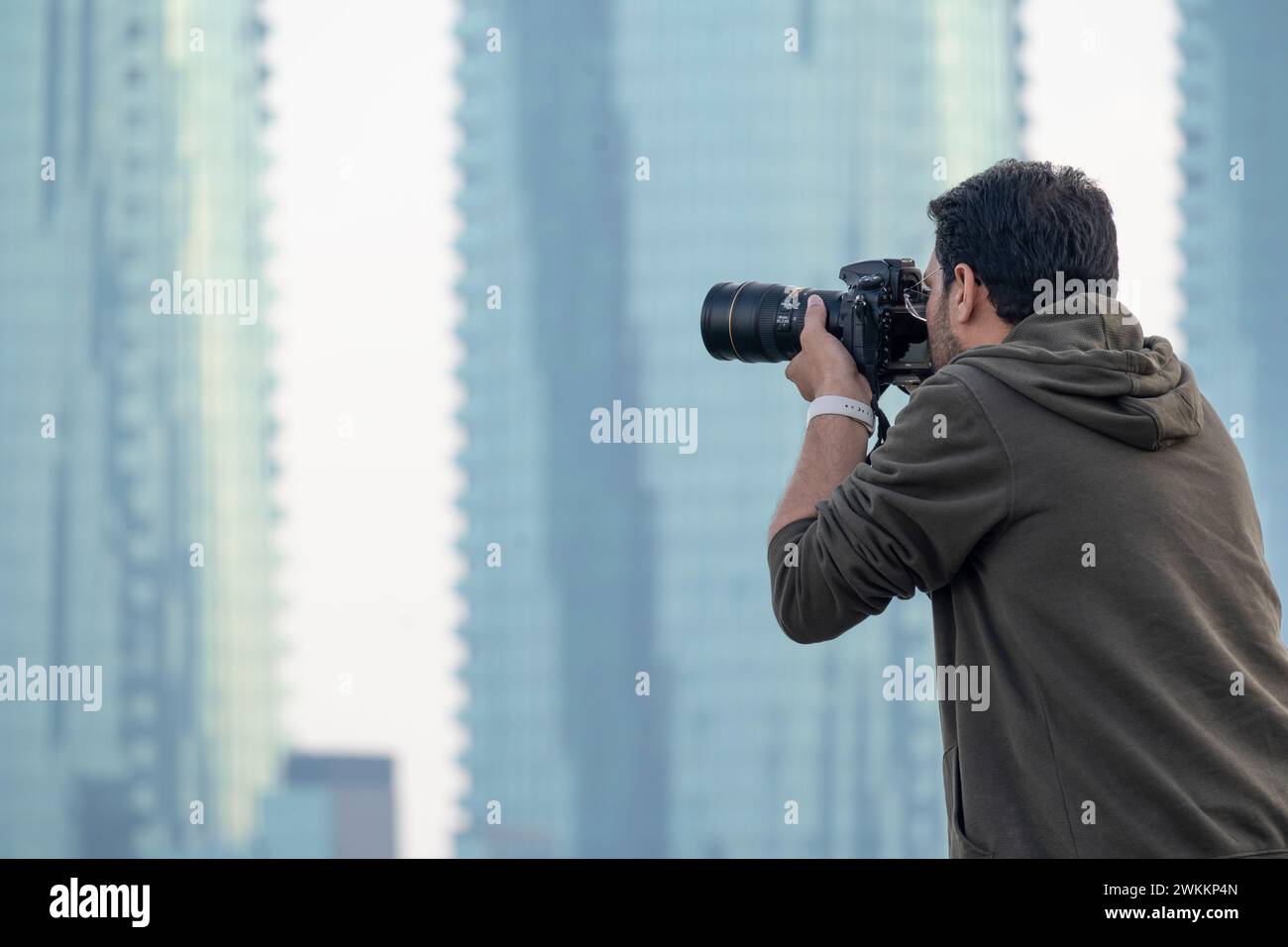 Male Photographer taking photos of skyline Manama City Bahrain Stock Photo