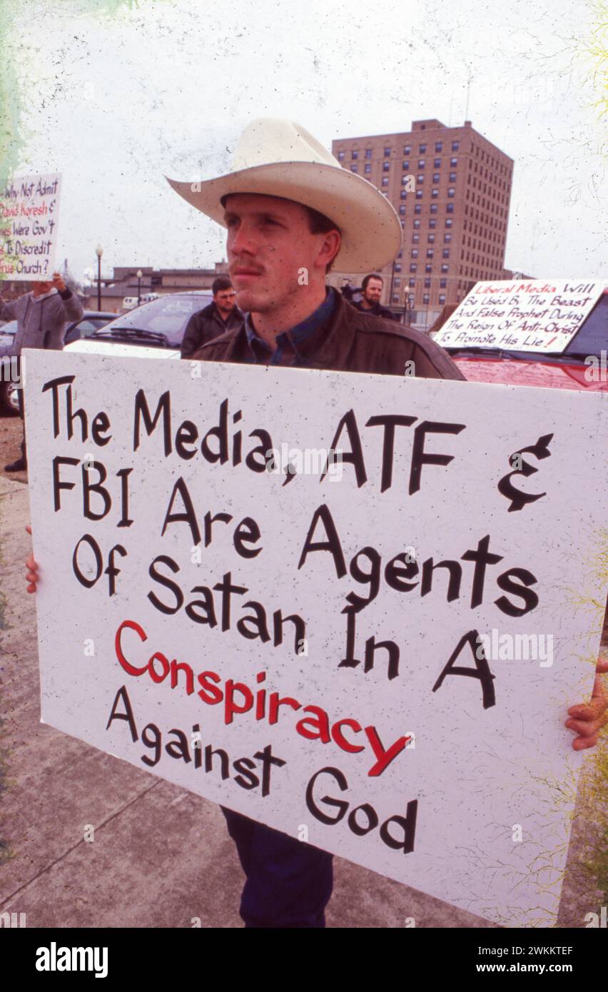 Waco Texas USA, 1993: Young man wearing cowboy hat carries sign protesting how the media and federal agents are handling a days-long armed standoff against the Branch Davidian religious sect.  ©Bob Daemmrich Stock Photo