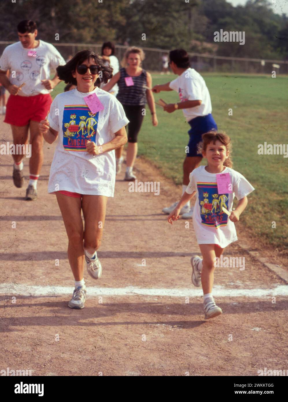 Mother and daughter cross the finish line of a one-mile run at a fitness fair sponsored by physical education teachers. ©Bob Daemmrich Stock Photo
