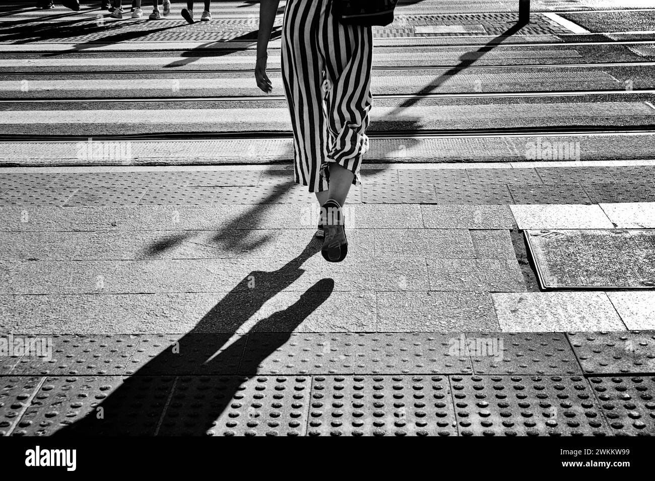 Woman legs walking downtown on the crosswalk in a European city Stock Photo