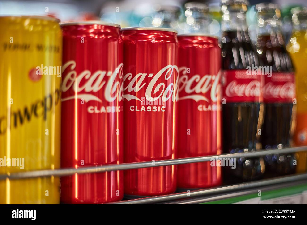 Shelf in store with soda of different brands. Coca Cola, schweppes. Aluminum cans and glass bottles of various sizes. Beverage editorial, popular carb Stock Photo