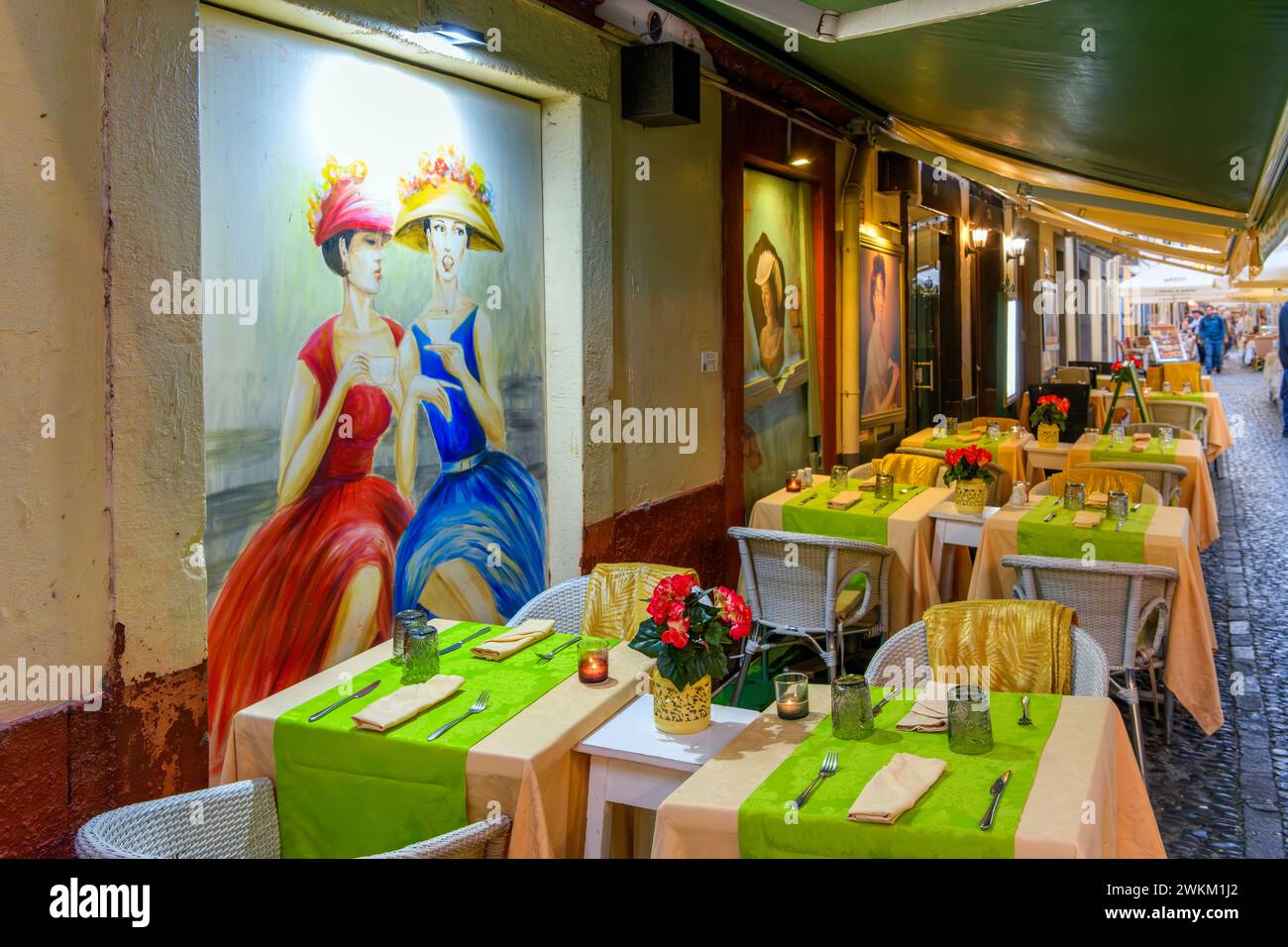 A sidewalk cafe on Rua de Santa Maria, the famous narrow alley of painted doors in the old town of Funchal Madeira, Portugal, in the Canary Islands. Stock Photo