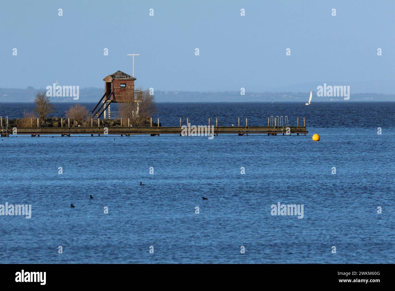 Oxford Island National Nature Reserve, Oxford Island, Lough Neagh, County Armagh, Northern Ireland, UK. 21st Feb 2024. UK weather - a pleasant day with long sunny spells and blue sky.. A yacht sails on Lough Neagh on a sunny February afternoon. Credit: CAZIMB/Alamy Live News. Stock Photo