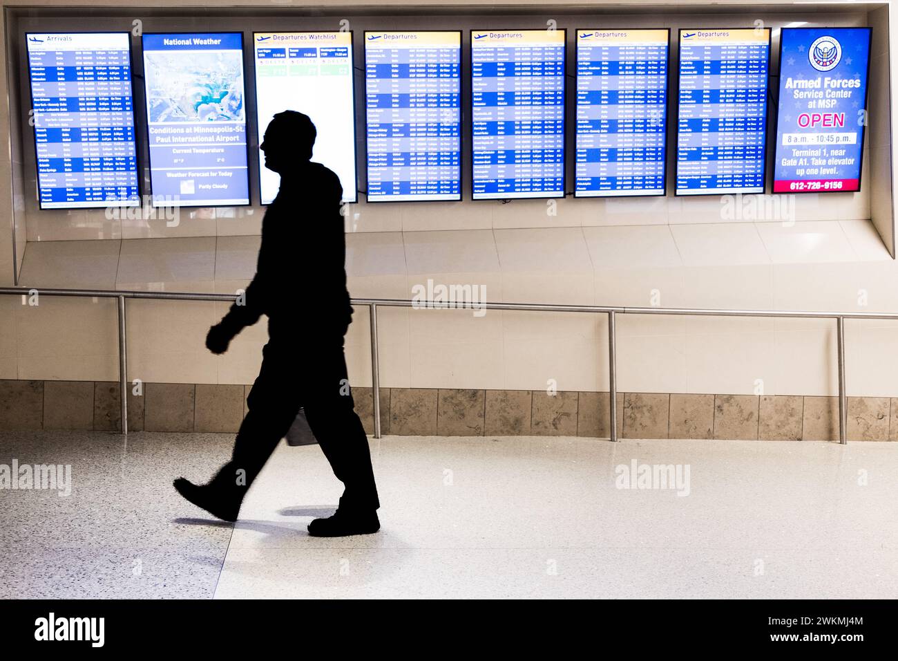 Air traveler and the arrival-departure display at the Minneapolis-St. Paul airport, USA (MSP) during a typical airport travel day. Stock Photo
