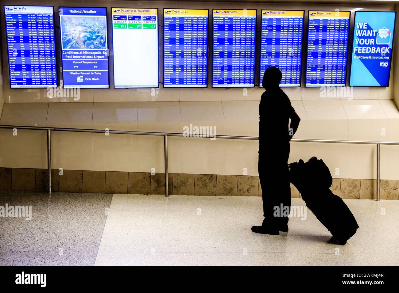 Air travelers and the arrival-departure display at the Minneapolis-St. Paul airport, USA (MSP) during a typical airport travel day. Stock Photo