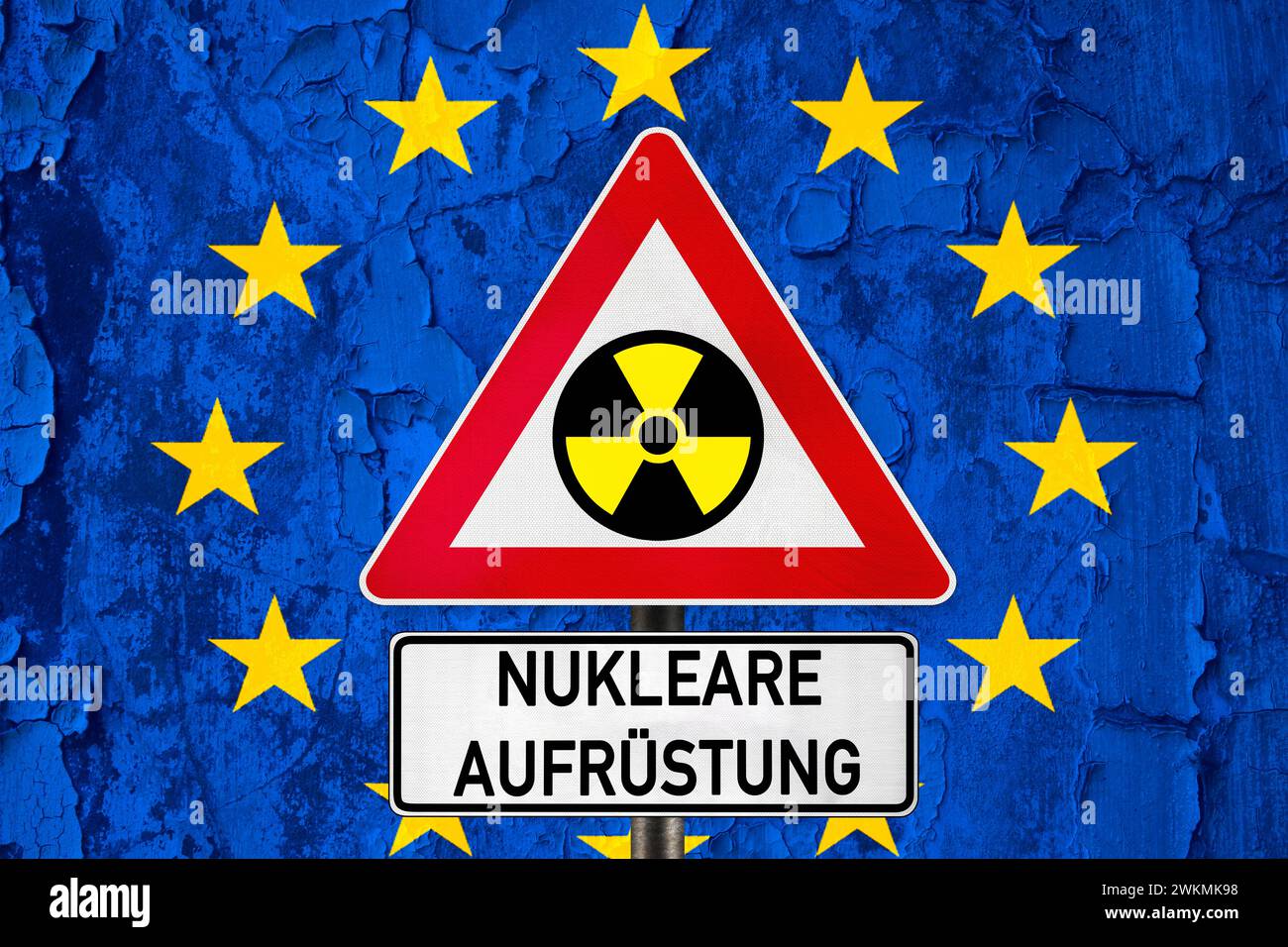 February 21, 2024: Nuclear armament, lettering on a sign in front of EU flag with nuclear symbol. Armament of nuclear weapons in Europe. PHOTOMONTAGE *** Nukleare Aufrüstung, Schriftzug auf einem Schild vor EU-Flagge mit Nuklear Symbol. Aufrüstung von Nuklearwaffen in Europa. FOTOMONTAGE Stock Photo