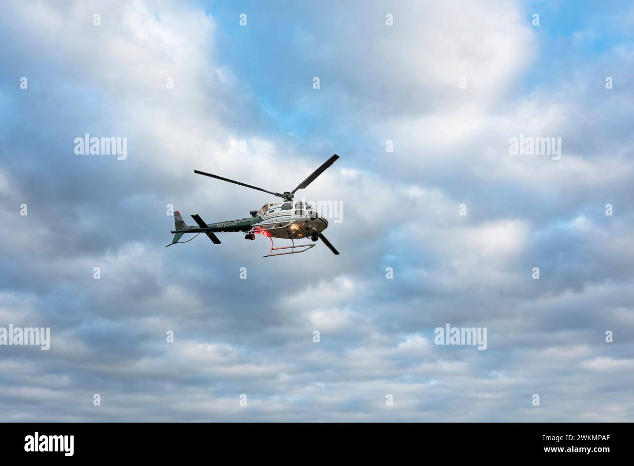 Lake Elsinore, CA, USA - February 19, 2024: Riverside County Sheriffs helicopter flies over Lake Elsinore, C Stock Photo