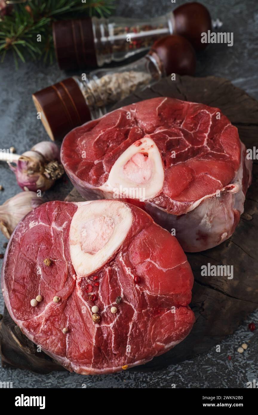 ossobuco. Raw beef ossobuco steak, Italian ossobuco with cooking spices. Black background. Top view. Stock Photo