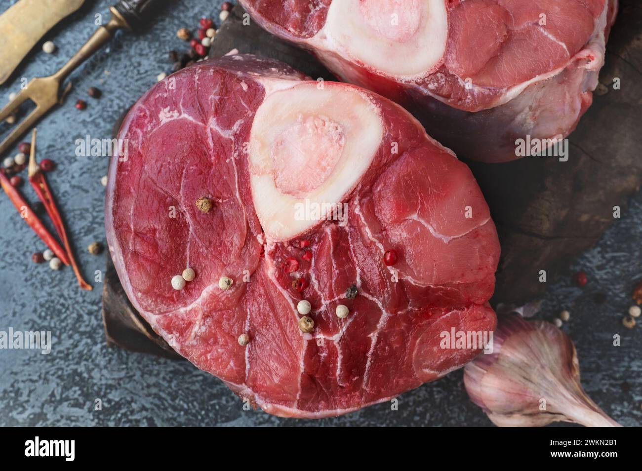 ossobuco. Raw beef ossobuco steak, Italian ossobuco with cooking spices. Black background. Top view. Close-up Stock Photo