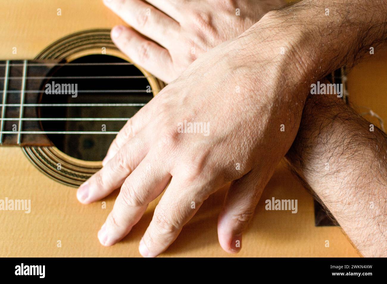 Hands of a classical guitarist on top of the guitar. Stock Photo
