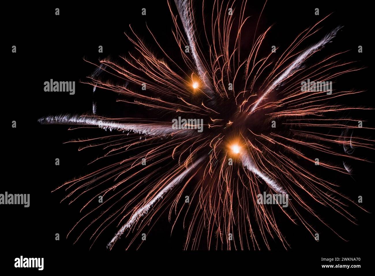 Blue, red, orange and white fireworks in night sky. Stock Photo