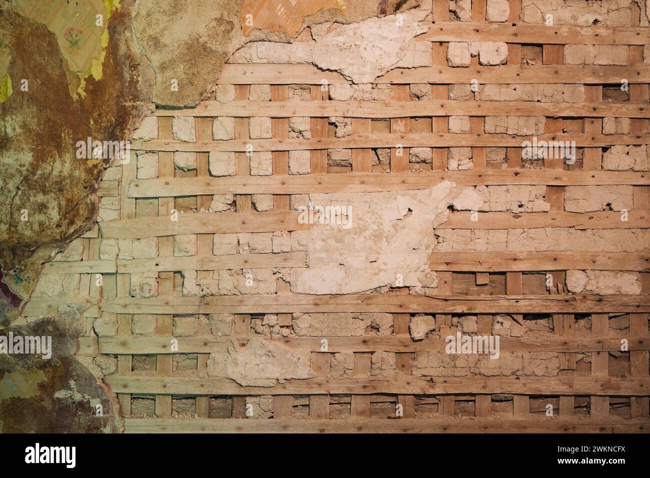 Partially demolished plaster and wooden lattice wall in room inside old 1800s home. Stock Photo