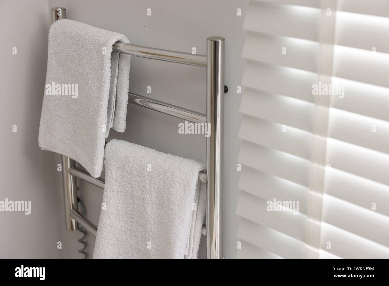 Heated towel rail with towels in bathroom Stock Photo - Alamy