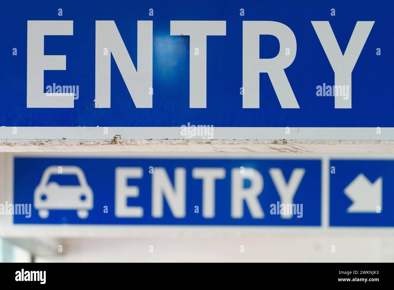 Public car park access point with entry sign, direction arrow and car symbol, white lettering on blue background, Melbourne city, Australia. Stock Photo