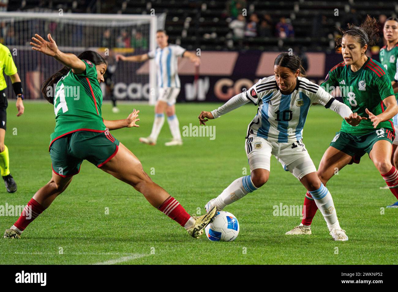 Argentina midfielder Dalila Ippólito (10) is challenged by Mexico defender Rebeca Bernal (4) and midfielder Alexia Delgado (8) during the Concacaf W G Stock Photo