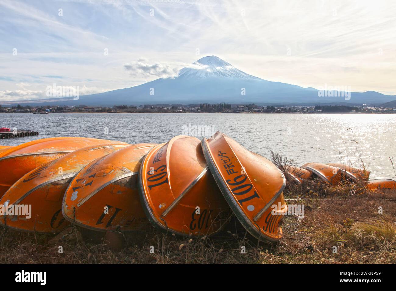 Lake Kawaguchi with Mt. Fuji in the background and several orange colored boats in the foreground. Stock Photo