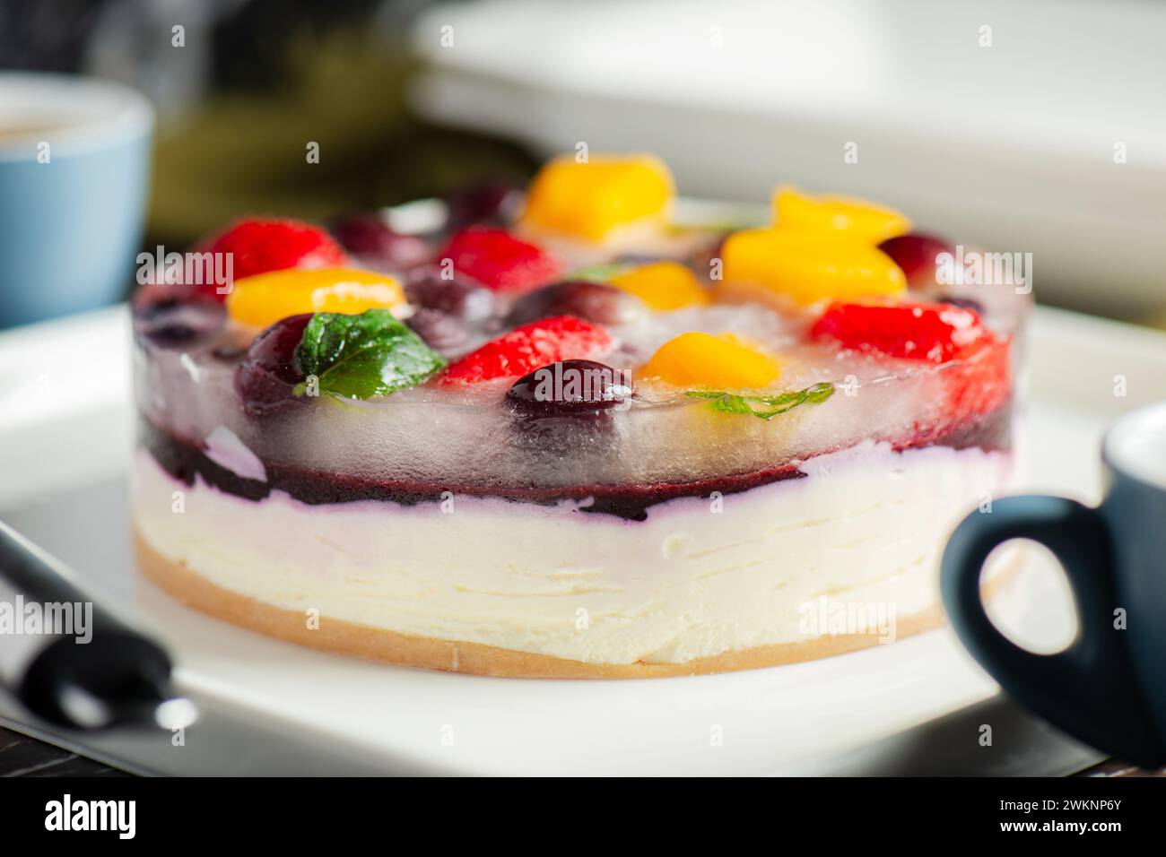 Delicious and light no-bake cheesecake with summer fruits including strawberry, mango, and grapes. Stock Photo