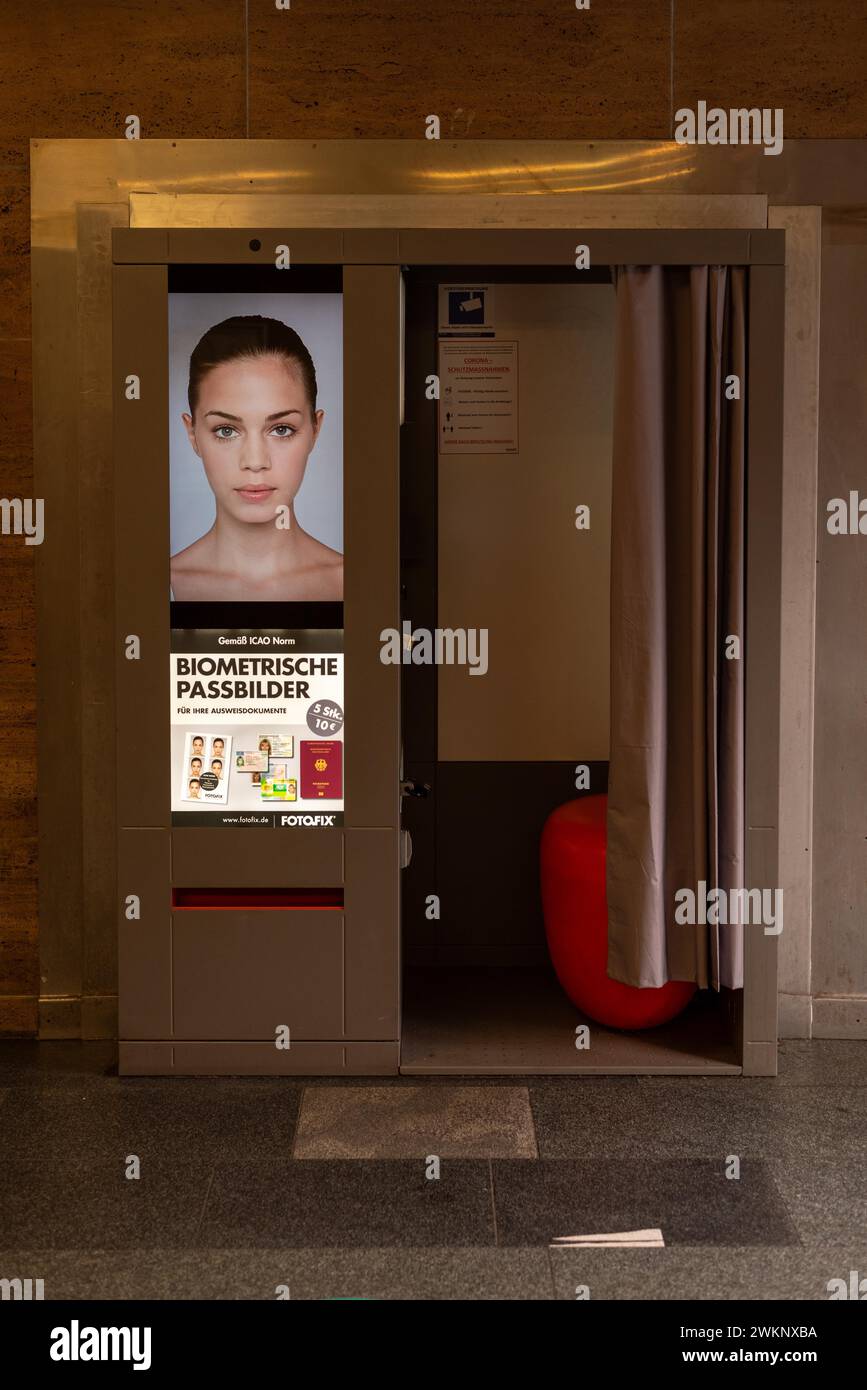A photo booth for biometric passport photos with a female face on the advertising poster, Magdeburg, Saxony-Anhalt, Germany Stock Photo