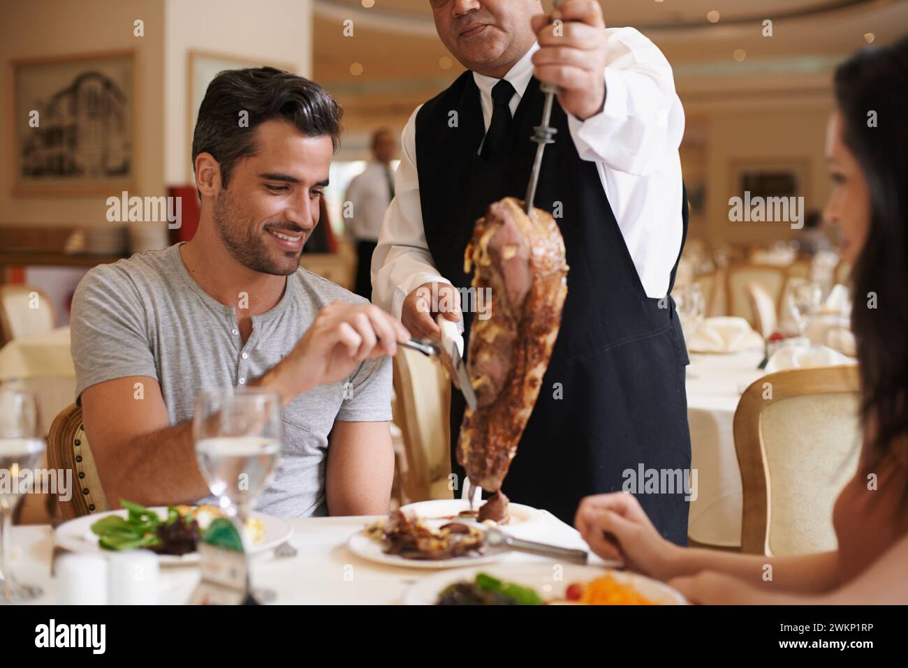 Couple, server and service for dinner in restaurant with meat