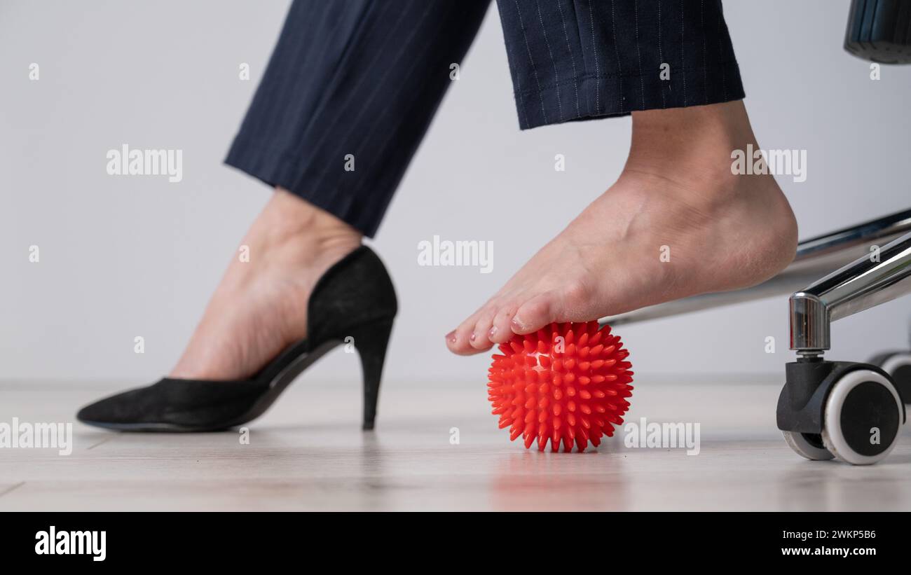 Business woman massages her feet on a massage ball with spikes Stock ...
