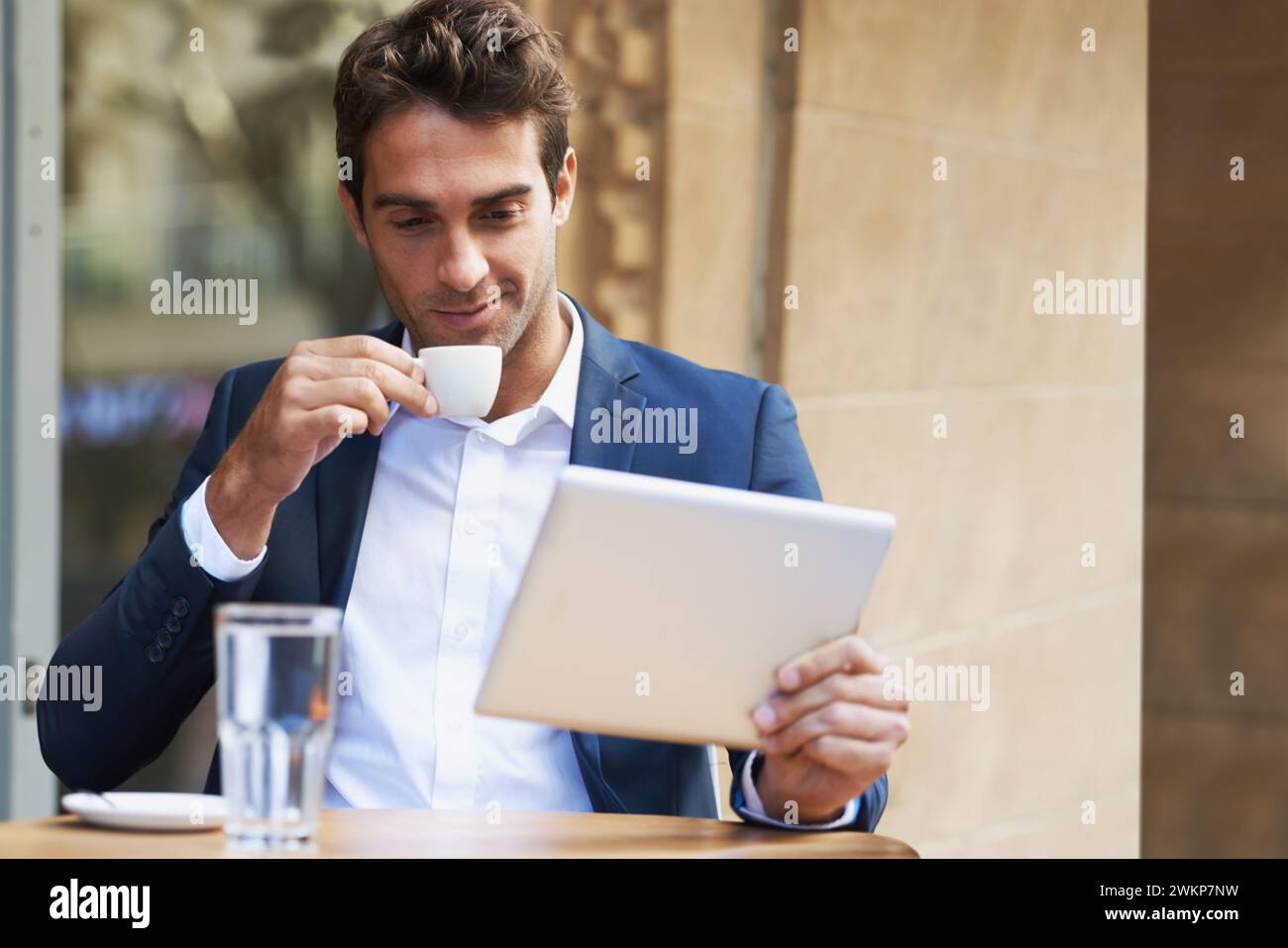 Businessman, outdoor and reading at cafe with tablet for news, article or internet research in London. Online, communication and drink espresso with Stock Photo