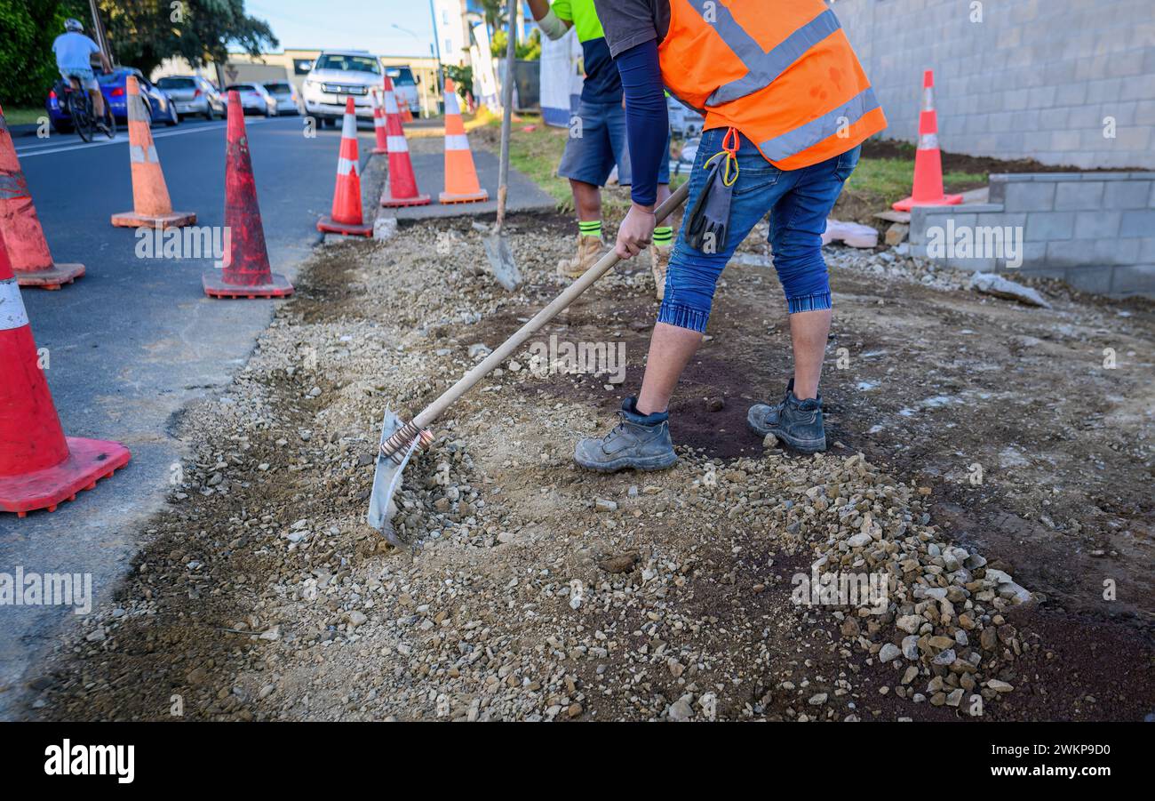 Road resurfacing. Workers repairing the road. Traffic cones along the road. Auckland. Stock Photo