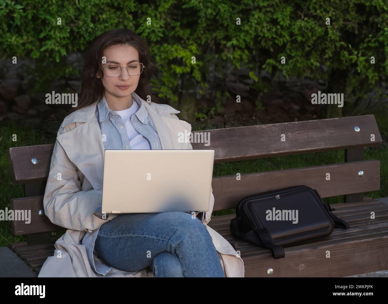 girl working at a laptop in the park on a bench Stock Photo - Alamy