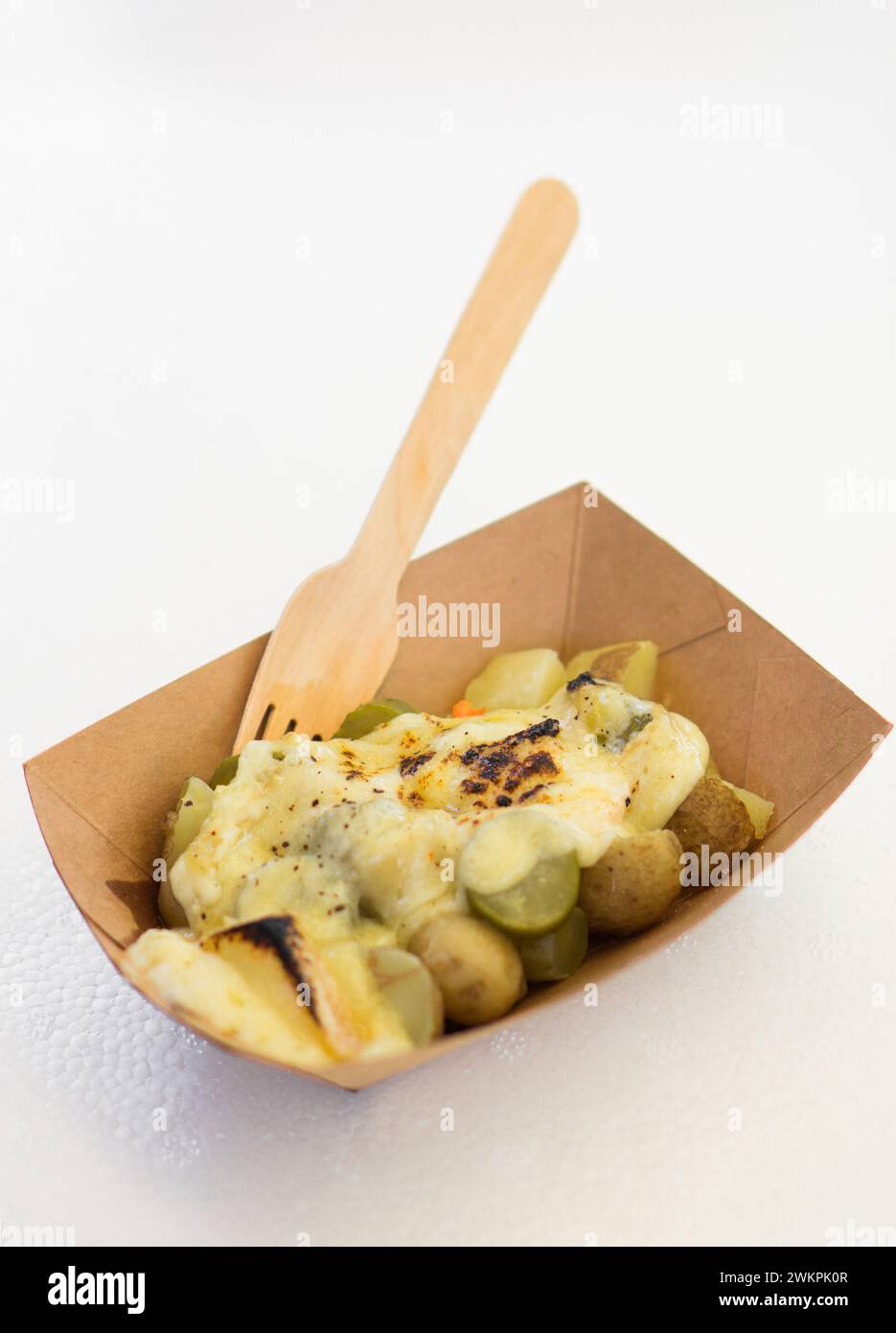 A wooden bowl filled with potato salad and topped with chives Stock Photo