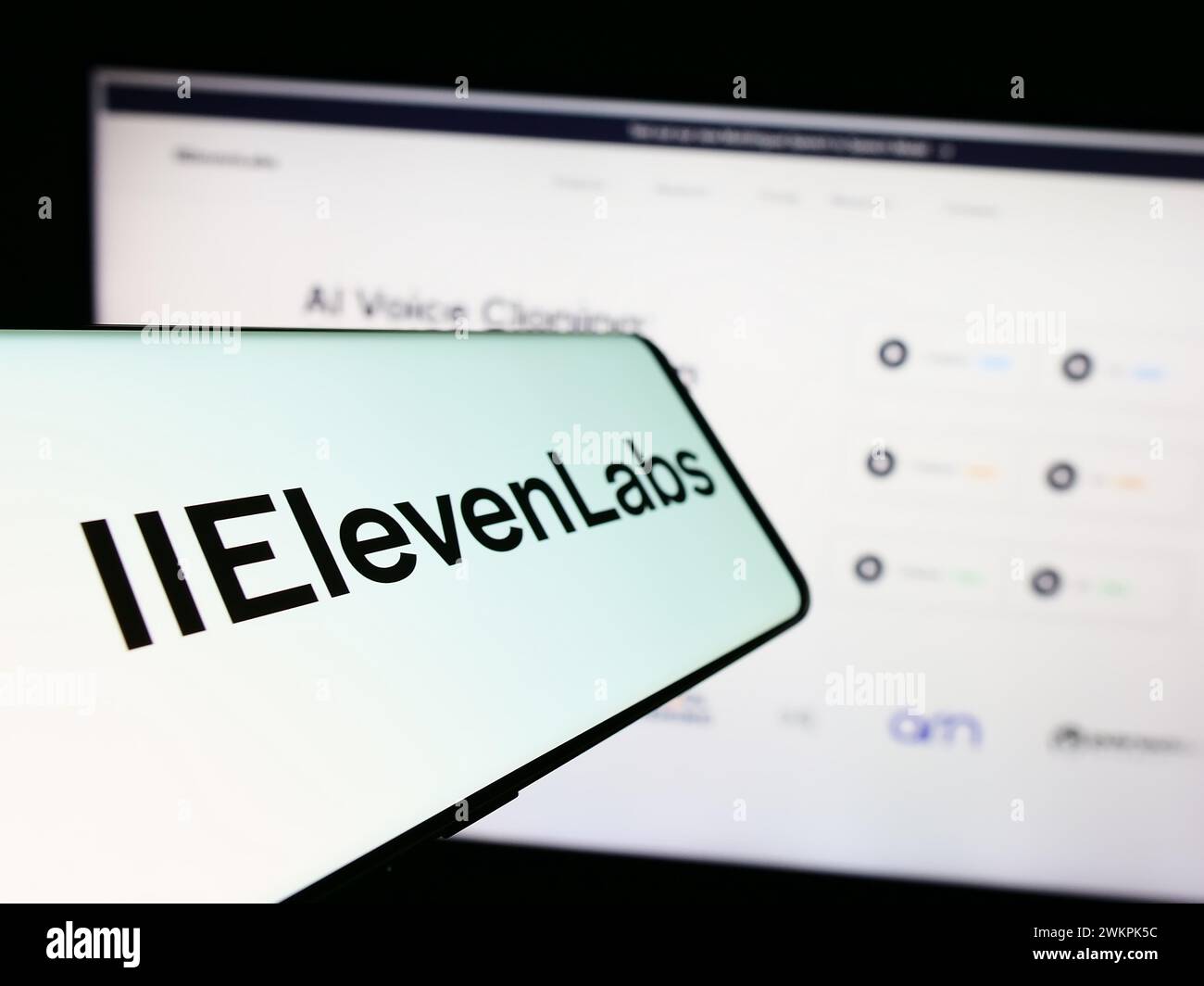 Cellphone with logo of American artificial intelligence company ElevenLabs Inc. in front of website. Focus on center-left of phone display. Stock Photo