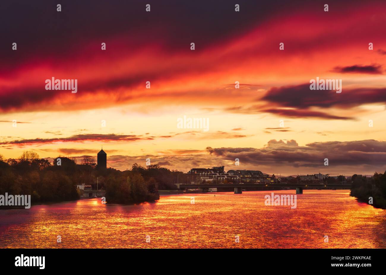 Dramatic stunning red sky at sunset, a romantic scenery over the Neckar river in Heidelberg, Germany Stock Photo
