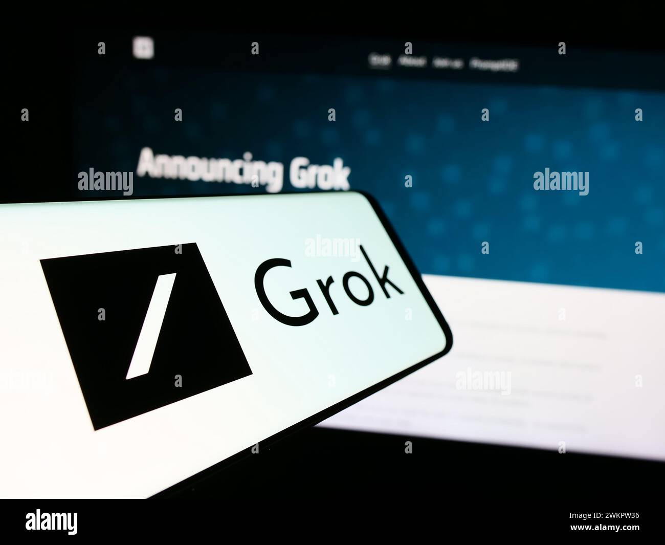 Mobile phone with logo of generative artificial intelligence chatbot Grok (X.AI) in front of website. Focus on center-left of phone display. Stock Photo