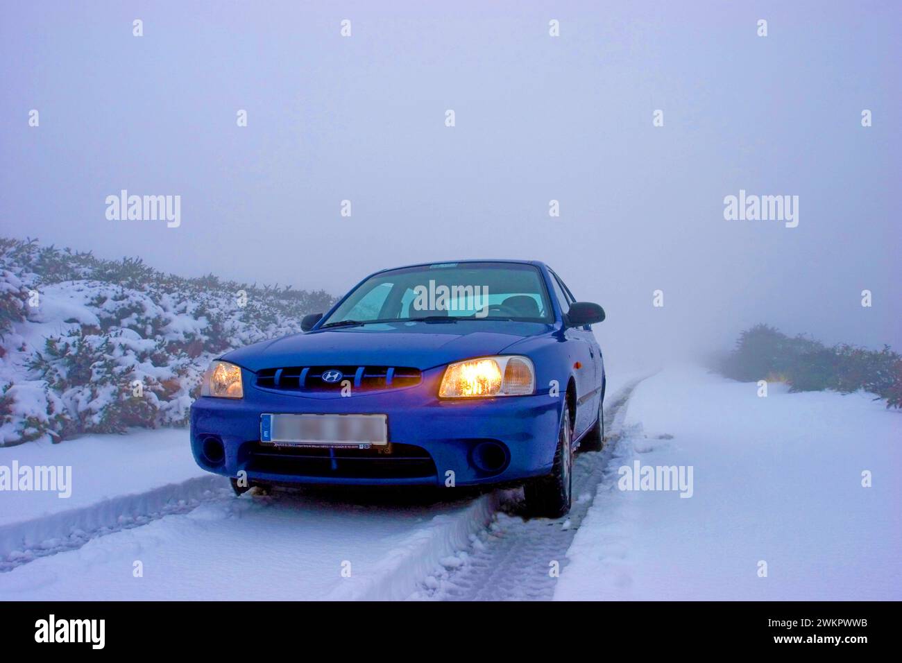 blue rental car in the snow of the highest mountain Roque de los