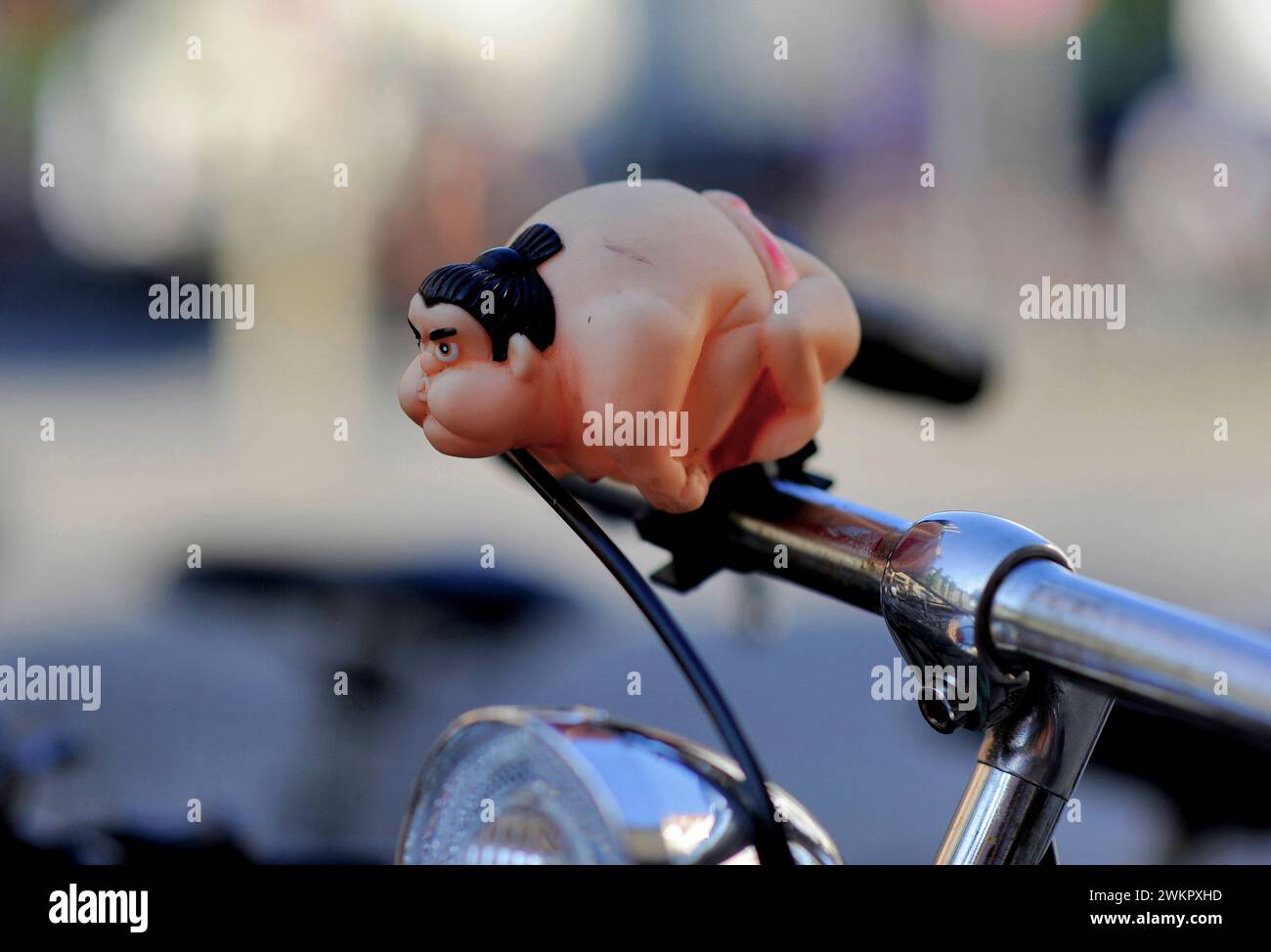 a sumo wrestler attached to the handlebars of a bicycle as a bicycle horn or bell Stock Photo