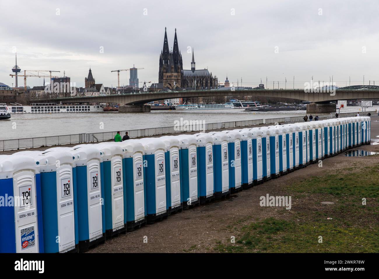 a large number of porta-potties are located after the carnival days at Deutzer Werft, banks of the Rhine in the district Deutz, view to the cathedral, Stock Photo