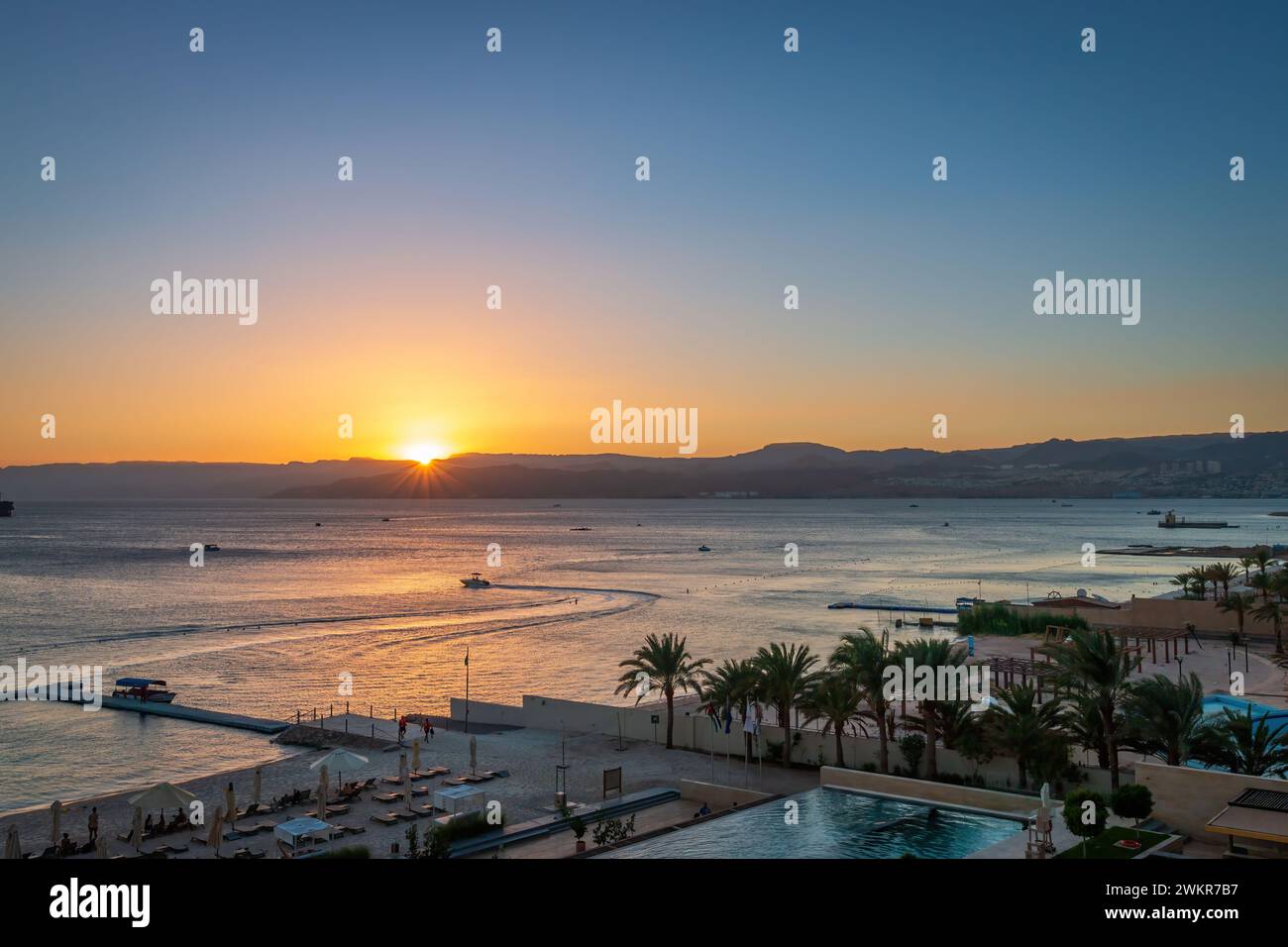 Scenic view of swimming pool and beach at Gulf of Aqaba in Aqaba, Jordan at sunset Stock Photo
