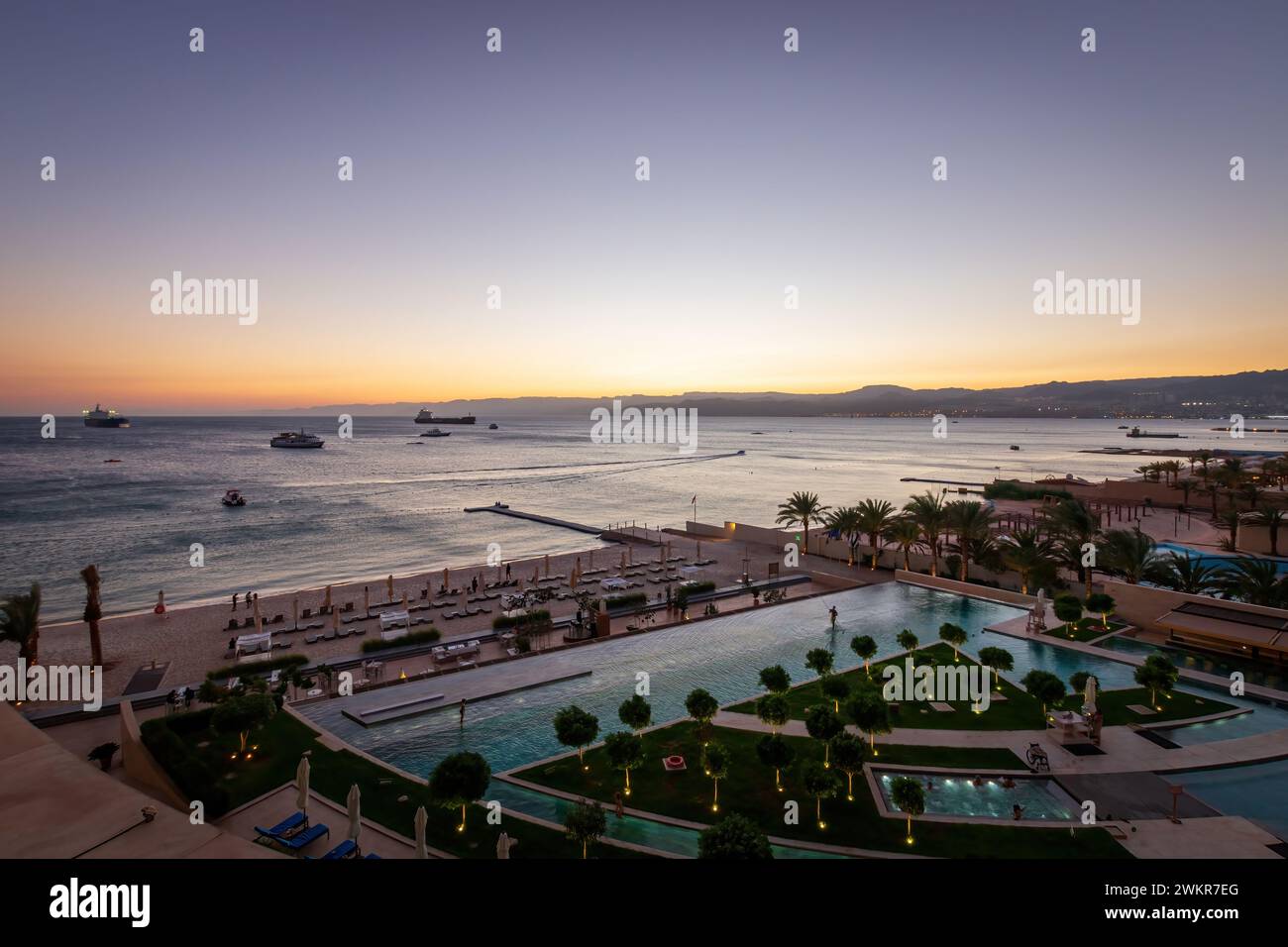 Scenic view of swimming pool and beach at Gulf of Aqaba in Aqaba, Jordan at sunset Stock Photo