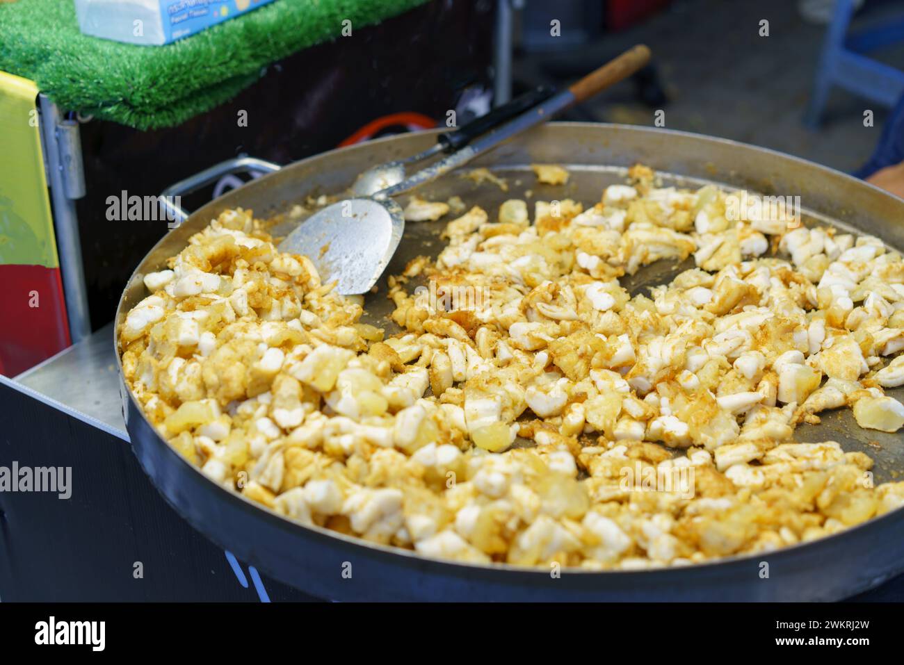 Fresh squid being fried to perfection in a large pan at a bustling street food market, a popular snack among locals and tourists alike Stock Photo