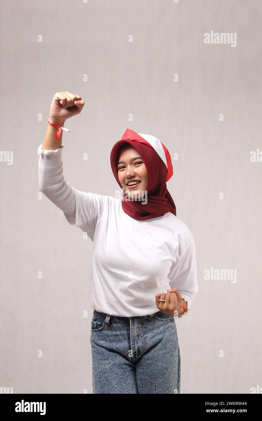 young asian woman wearing stylish red headscarf hand holding successful celebrating victory, indonesia independence day concept Stock Photo
