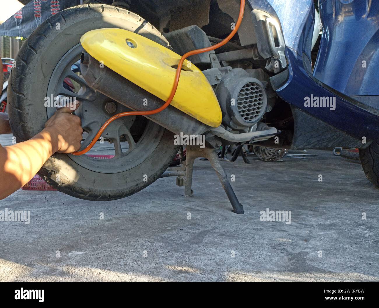 A motorcycle mechanic is adding air to a tire Stock Photo Alamy