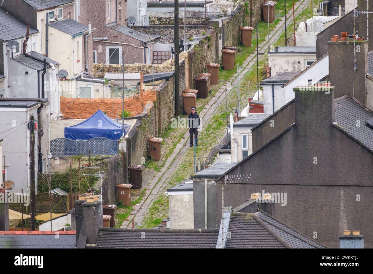 A police officer stands in a back alley after homes were evacuated when ...