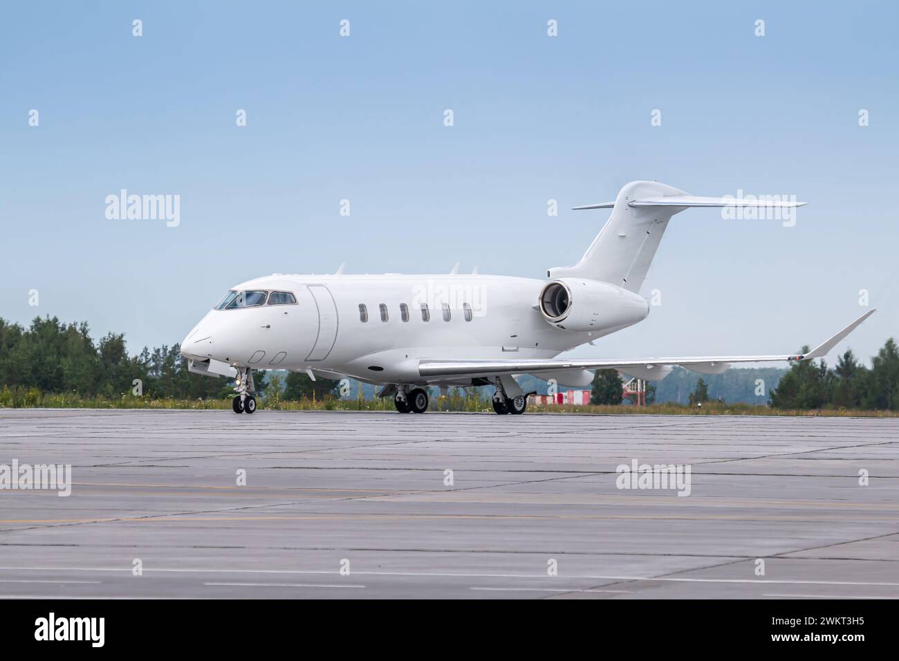 White luxury business jet taxiing on airport taxiway Stock Photo