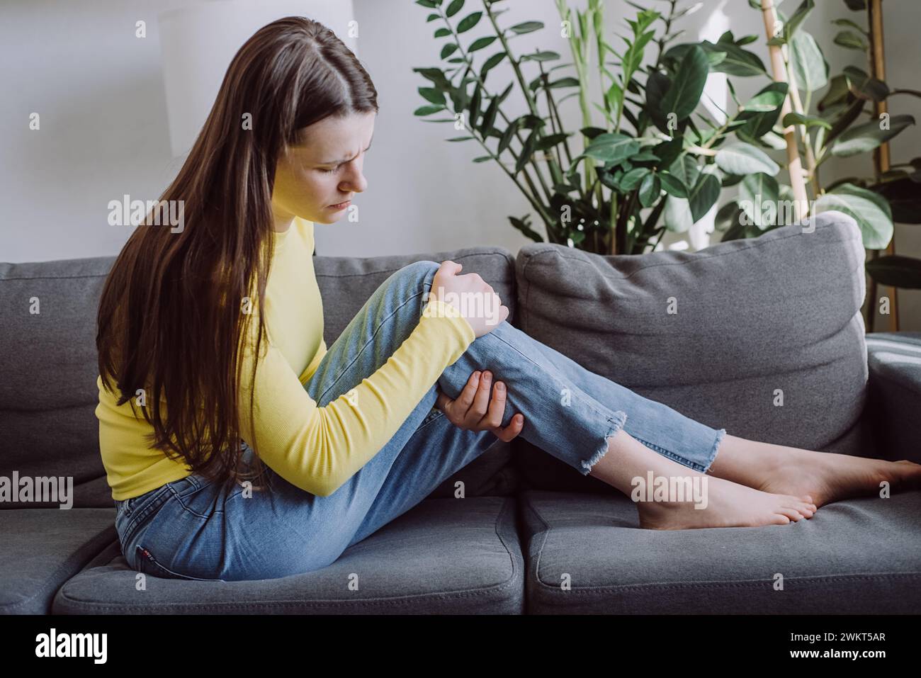 Muscle pain or leg pain, sad young female massaging brawn leg calf