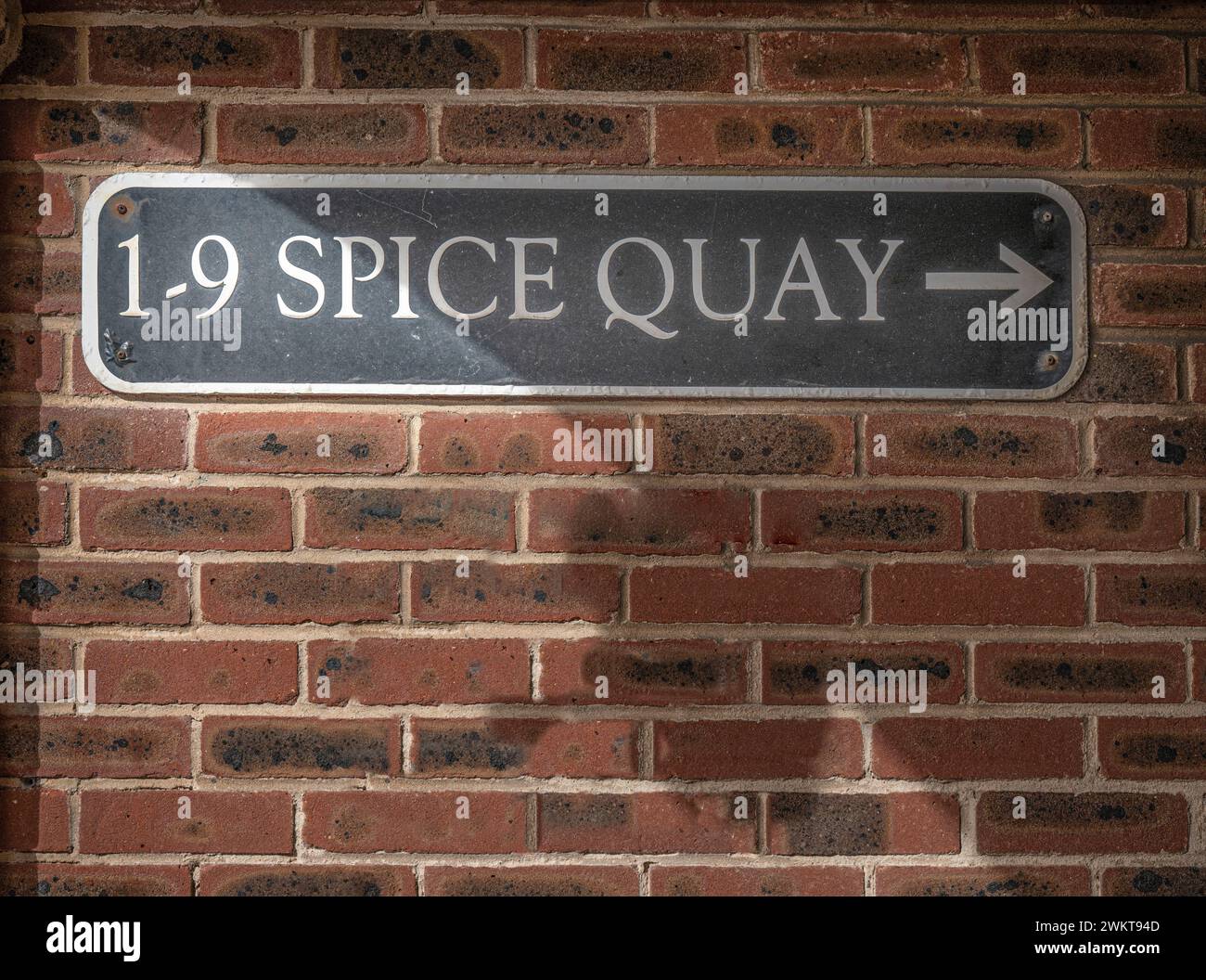 Sign on brick wall indicating direction to Spice Quay, Old Portsmouth, UK. Stock Photo